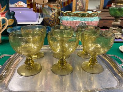 quatre verres posés sur un plateau en argent, sur une table