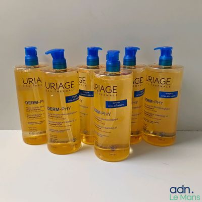 four bottles of uriage body wash sitting on a table