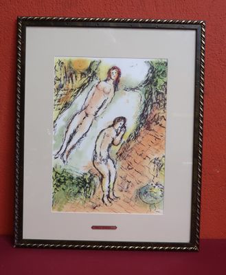 tableau représentant deux nus, accroché à un mur rouge dans un cadre