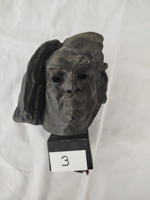 une sculpture représentant la tête d'une femme posée sur un socle