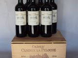 quatre bouteilles de vin rouge dans un coffret en bois posé sur une table