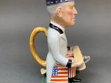 a figurine of a man sitting on a book