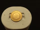 une pièce d'or posée sur un anneau blanc