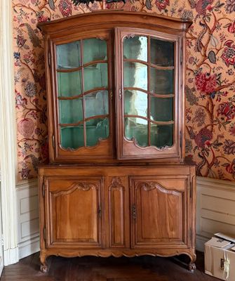 un meuble en bois avec une porte en verre dans une pièce