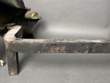 a metal sculpture of a cow sitting on a bench