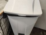 a trash can sitting next to a trash can in a room