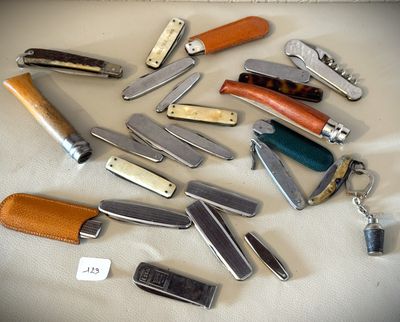 de nombreux types de couteaux de poche posés sur une table