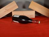 a bottle of wine sitting on a table next to a wooden box