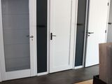 doorways and doors in a room with hardwood floors and a television