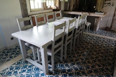 une table et des chaises blanches au milieu d'une pièce