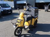 a yellow scooter that is parked in a parking lot