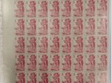 a close up of a sheet of red and white stamps on a sheet of paper