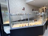 une photo d'une boulangerie avec une vitrine remplie de pâtisseries