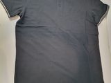 a grey polo shirt sitting on top of a white box