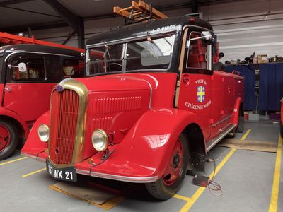 two red fire trucks parked in a garage