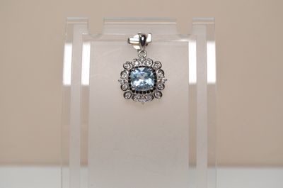 a pendant with a blue topaz stone in it