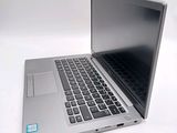 a silver laptop with a black keyboard on a white surface