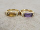 two gold rings with amethorate and diamonds on a table