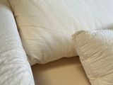 two pillows on a bed with a white cover