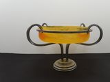 an image of a yellow glass vase with two handles on a black table