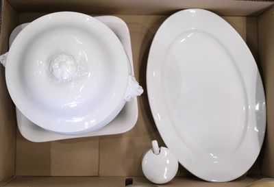 deux assiettes blanches et un bol dans une boîte