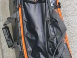 a black and orange luggage bag sitting on the ground