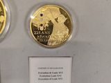 two gold coins are on display in a glass case