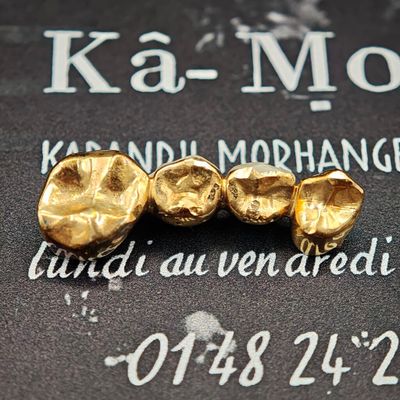 trois pépites d'or posées sur un livre noir