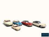 several toy cars are lined up in a row on a white surface