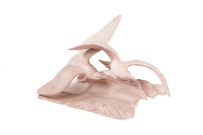 a sculpture of a bird sitting on top of a piece of wood