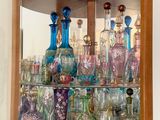 de nombreux vases en verre de différentes couleurs dans cette vitrine