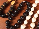three necklaces that are sitting on a wooden table