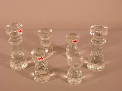 cinq bougeoirs en verre posés sur une surface blanche