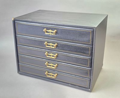 a small blue chest of drawers with gold handles