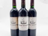 trois bouteilles de vin rouge posées l'une à côté de l'autre sur une surface blanche