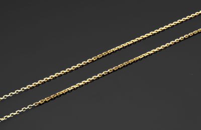 une paire de colliers à chaîne en or sur fond noir