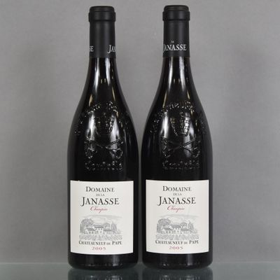 two bottles of red wine sitting on top of a glass table
