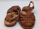 a pair of brown sandals on a white surface
