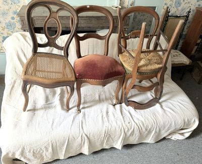 trois chaises posées sur un lit dans une chambre