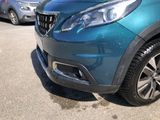 a blue car parked in a parking lot with other cars in the background