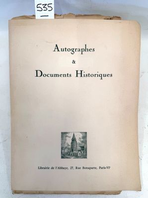 an old book sitting on top of a table next to a white wall