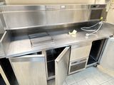 une grande cuisine en inox équipée d'un évier et d'un réfrigérateur