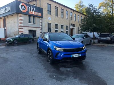 the blue car is parked in front of a building in a parking lot