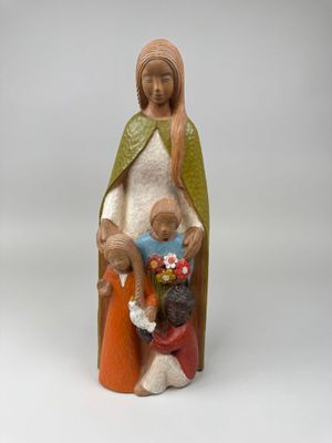figurine de femme tenant un enfant et un chien
