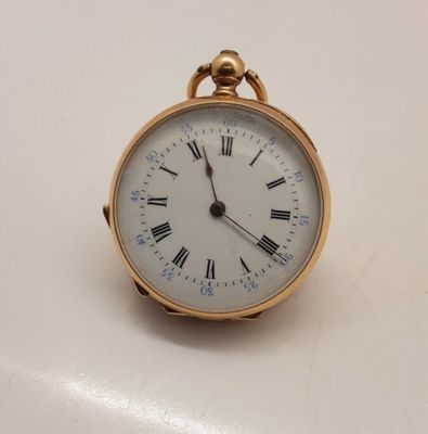 une petite montre de poche en or avec des chiffres romains