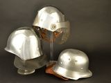 three silver helmets sitting on top of each other on a table
