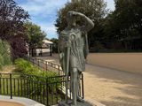 a statue of a man with a hat on a pedestal
