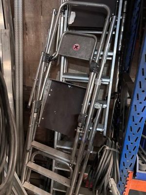 une pile de chaises et une échelle dans une pièce
