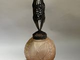 a person that is holding a glass vase with a bird on it