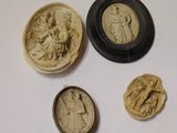 trois petits camées sculptés représentant des femmes et des hommes, dans un cadre noir